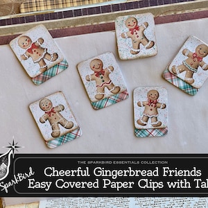 May include: Six gingerbread man paper clips with tabs. Each clip features a different gingerbread man design with red and white plaid accents. The clips are decorated with white sprinkles and red bows. The text "SparkBird Cheerful Gingerbread Friends Easy Covered Paper Clips with Tabs" is at the bottom of the image.