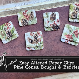 Puede incluir: Seis clips de papel decorativos con un tema invernal. Los clips presentan piñas, ramas y bayas en tonos de verde, marrón y rojo. El texto "The Sparkbird Essentials Collection Easy Altered Paper Clips Pine Cones, Boughs & Berries" está impreso en una pancarta negra debajo de los clips.