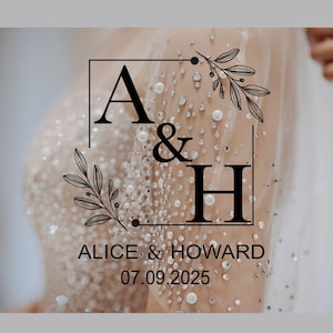 May include: A wedding invitation with a white background and a black square frame with the letters A & H inside. The letters are surrounded by a floral design. The text "Alice & Howard" and the date "07.09.2025" are below the frame.