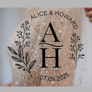 Pode incluir: Um design de casamento com os nomes "Alice & Howard" e a data "07.09.2025" em disposição circular. O design inclui as iniciais "A" e "H" com uma linha decorativa e elementos florais.