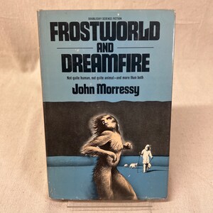 May include: A blue and black paperback book cover with the title "Frostworld and Dreamfire" in white lettering. The author's name, "John Morressy", is printed below the title. The cover features a black and white illustration of a humanoid figure with long hair and a tail, walking on a blue surface.
