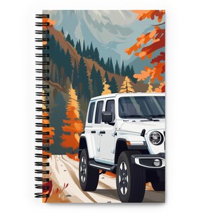 May include: A white Jeep Wrangler driving on a dirt road through a forest with fall foliage. The mountains are in the background.