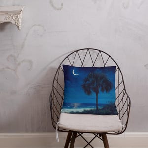 May include: A throw pillow with a blue and white design featuring a palm tree silhouette against a starry night sky with a crescent moon.