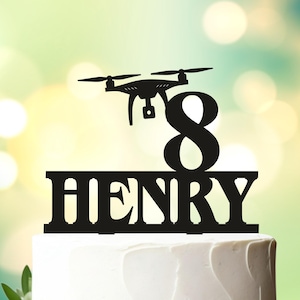 May include: Black acrylic cake topper featuring a drone, the number 8, and the name "HENRY".