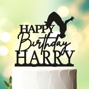 May include: Black silhouette cake topper with a person doing a backflip and the text "Happy Birthday Harry".
