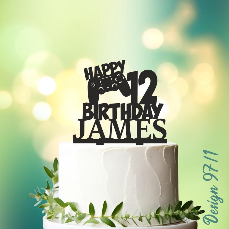 May include: Black and white cake topper with a video game controller, the number 12, and the words "Happy Birthday James".