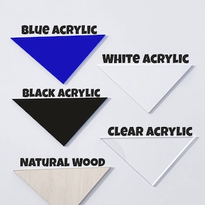 May include: Five triangular samples of different materials: blue acrylic, white acrylic, black acrylic, clear acrylic, and natural wood. Each sample has the material name printed in black.