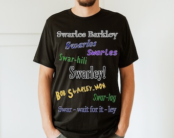 Puede incluir: Una camiseta negra con una variedad de texto colorido impreso en la parte delantera. El texto incluye los nombres "Swarles Barkley", "Swarlos", "Swar-hili", "Swarles", "Swarley!" y "BOB SWARLEY MON".
