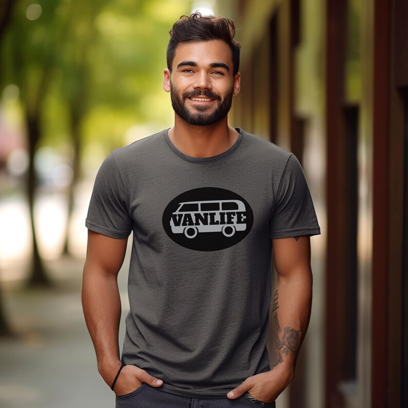 A man in a dark grey t-shirt with a black embellishment featuring a graphic of a van that reads VAN LIFE