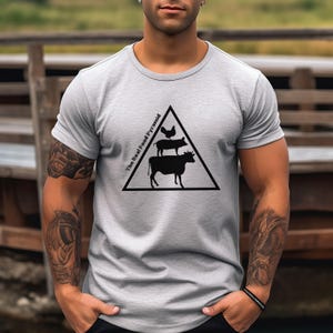 May include: A gray t-shirt with a black graphic of a pyramid with the text "The Real Food Pyramid" and a chicken, pig, and cow stacked on top of each other.