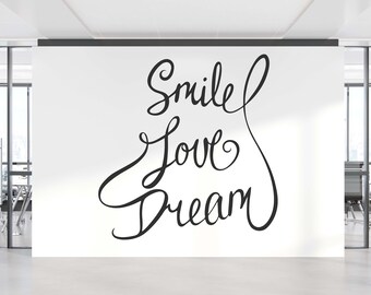 May include: A white wall with black calligraphy that reads "Smile Love Dream" in a modern office setting.