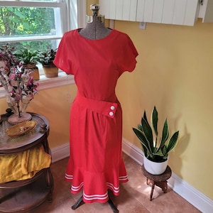 Ende der 1970er Jahre Anfang der 1980er Jahre Deadstock rotes Kleid mit offenem Rücken, gestreifter Rockrüsche und asymmetrischem Gürtel.