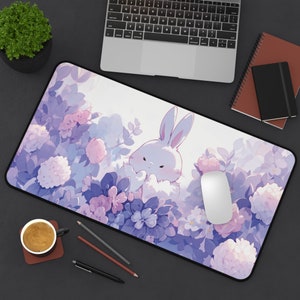 Op de afbeelding: Een paarse en witte muismat met een schattig cartoonkonijn omringd door bloemen. De muismat is ontworpen voor gebruik met een computermuis.