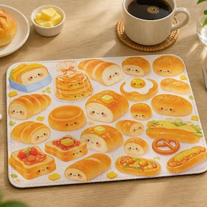 May include: A placemat featuring various types of bread with cute, smiling faces. The image includes a bun, butter, a cup of coffee, and silverware. The bread designs include toast, a pretzel, a hot dog, and a sandwich.
