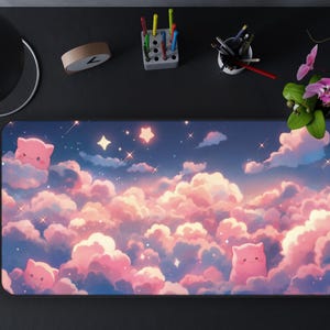 May include: A rectangular mousepad featuring a dreamy sky scene with fluffy pink and white clouds, stars, and cute pink cat-like characters. The design is set against a blue sky background, creating a whimsical aesthetic.