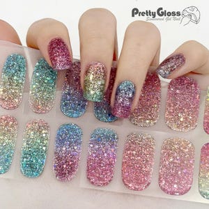 May include: A sheet of 10 colorful glitter nail wraps with a rainbow ombre effect. The nail wraps are designed to be applied over natural nails or gel polish. The nail wraps are semi-cured gel nail wraps from Pretty Gloss.