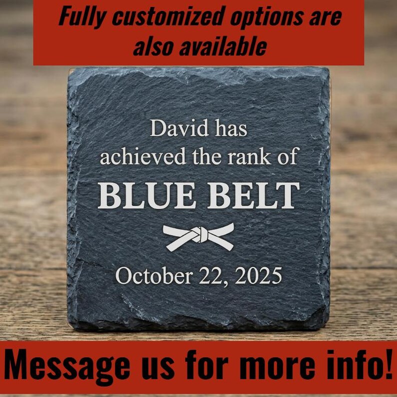 Op de afbeelding: Een donkergrijze leistenen onderzetter met de tekst "David heeft de rang BLUE BELT behaald" en de datum "22 oktober 2025". De onderzetter heeft ook een witte riemafbeelding. De tekst "Volledig aangepaste opties zijn ook beschikbaar" en "Neem contact met ons op voor meer info!" zijn ook aanwezig.