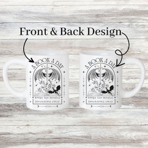 May include: White ceramic mug with a black and white illustration of a book, a sword, and a dragon. The text "A Book A Day Keeps The Mental Breakdown Away" is printed on the mug.