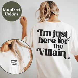 Puede incluir: Camiseta blanca con texto negro que dice "I'm just here for the Villain".