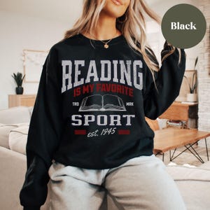May include: Black sweatshirt with the text "Reading is my favorite sport est. 1945" and a graphic of an open book.