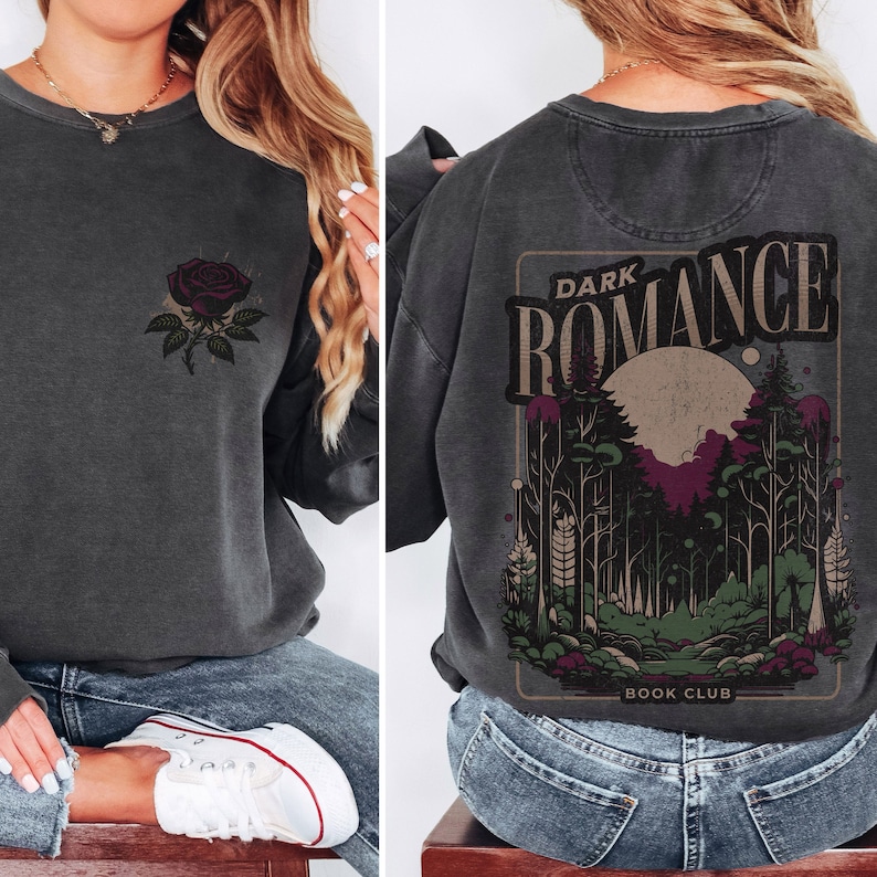 May include: A dark gray sweatshirt with a graphic print of a forest scene and the text "DARK ROMANCE BOOK CLUB" on the back. The front of the sweatshirt has a small graphic print of a black rose.