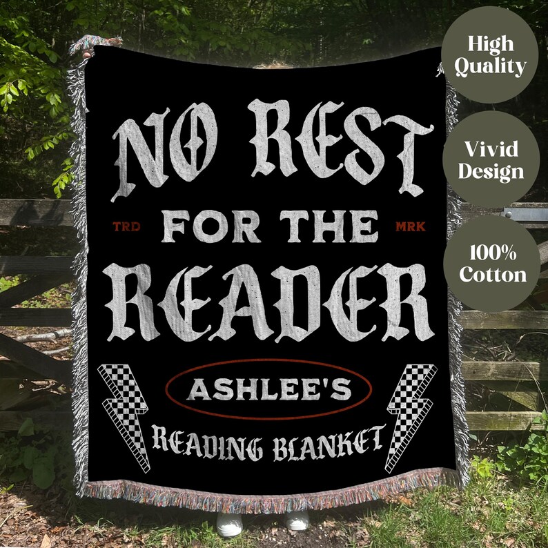 May include: Black reading blanket with white text that reads "NO REST FOR THE READER". The blanket includes the name "ASHLEE'S" and the words "READING BLANKET". The blanket has a checkered flag and lightning bolt design.