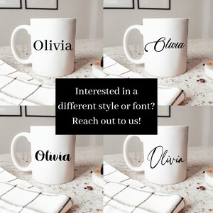 Op de afbeelding: Vier witte keramische mokken met de naam "Olivia" geschreven in verschillende lettertypen en stijlen. De mokken staan op een wit-zwart geruit oppervlak.