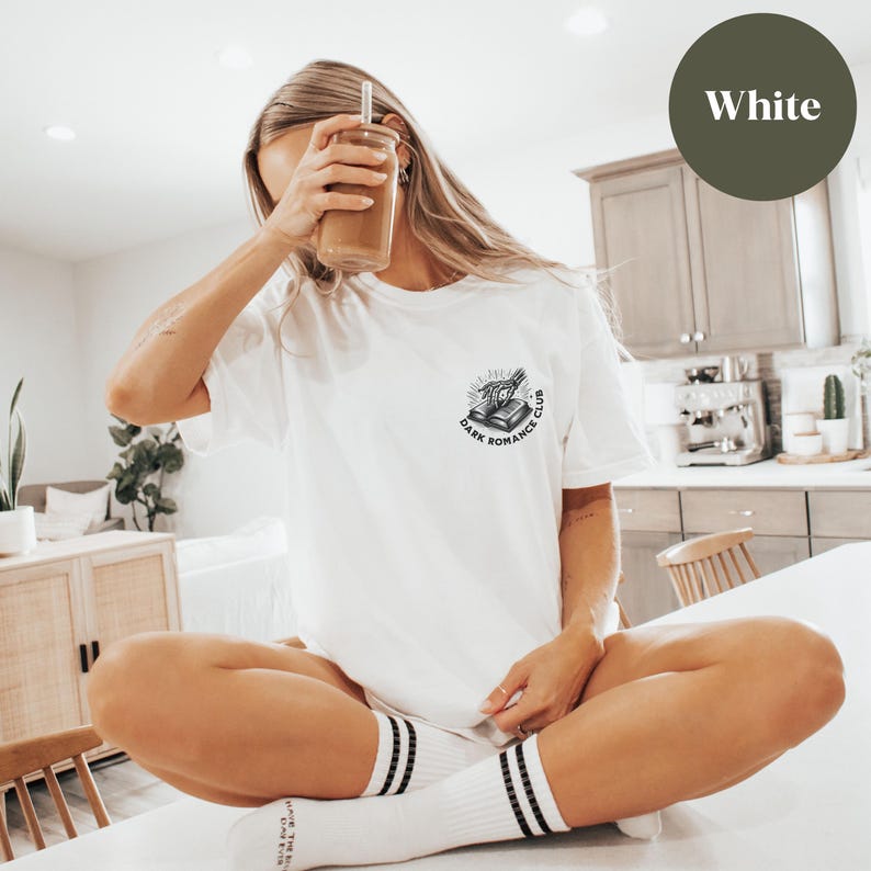 May include: White t-shirt with a black and white graphic of a book with an eye and the text "Dark Romance Club".