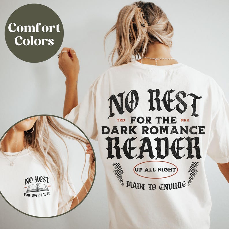 May include: White t-shirt with black text that reads "No Rest for the Dark Romance Reader" with a graphic of a book and lightning bolts. The text "Up All Night" and "Made to Endure" are also on the shirt.