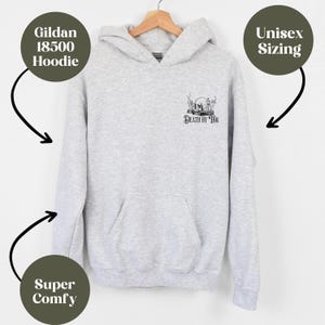 K&ouml;nnte beinhalten: Ein grauer Gildan 18500 Hoodie mit einem schwarz-wei&szlig;en Grafikdruck eines Sch&auml;dels mit einer Krone und dem Text "Death by Tea". Der Hoodie ist in Unisex-Gr&ouml;&szlig;en erh&auml;ltlich und wird als super bequem beschrieben.