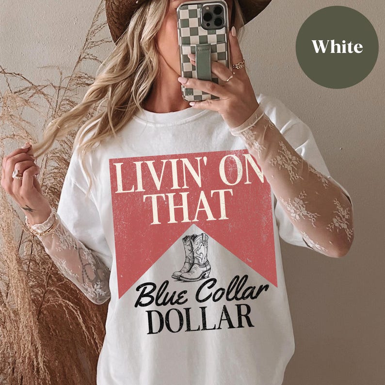 May include: White t-shirt with a red and white graphic that says "Livin' on That Blue Collar Dollar" and features a pair of cowboy boots.
