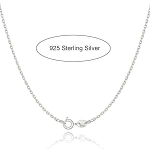 Puede incluir: Un collar de cadena de color plateado con un cierre de resorte redondo y una pequeña etiqueta ovalada estampada con S925. El texto 925 Sterling Silver aparece en una forma ovalada sobre la cadena, indicando la composición del material.