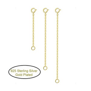 May include: Three gold-plated 925 sterling silver extender chains of varying lengths, each featuring a small circular clasp at the top and a jump ring at the bottom. The text 925 Sterling Silver Gold Plated is visible in an oval graphic.
