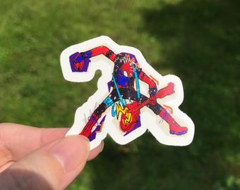 May include: A sticker featuring a stylized illustration of a superhero playing a red electric guitar. The superhero is depicted in a dynamic pose, wearing a black suit with red accents and blue suspenders. The sticker has a white border.