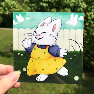 Puede incluir: Una pegatina cuadrada con un conejo de dibujos animados con un vestido amarillo con detalles florales verdes y mangas azules. El conejo está dibujado en una pose juguetona sobre un fondo de una valla blanca y hierba verde.