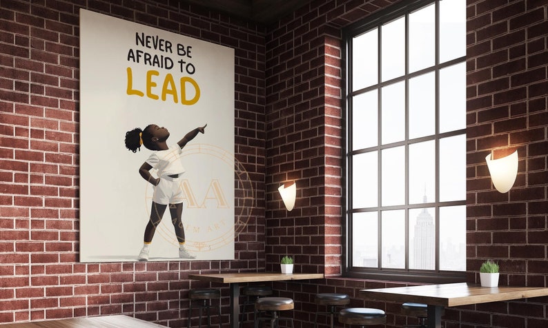 May include: A motivational poster with the text "NEVER BE AFRAID TO LEAD" and an illustration of a young Black child pointing upwards. The poster is displayed in a room with brick walls and a large window.