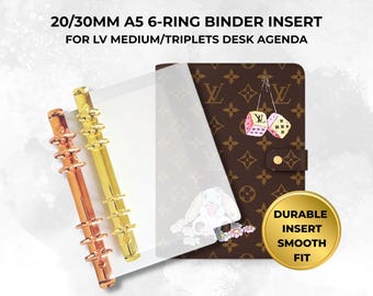 May include: A 20/30mm A5 6-ring binder insert for LV medium/triplets desk agenda. Includes two metallic ring mechanisms in rose gold and gold, a clear plastic sheet, and a brown monogram agenda cover with dice and rabbit graphics. Text reads: DURABLE INSERT SMOOTH FIT.