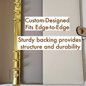 Może przedstawiać: Beżowo-taupowy segregator z sześciopierścieniowym mechanizmem w kolorze złotym. Wewnątrz znajduje się tekst: Custom-Designed Fits Edge-to-Edge oraz Sturdy backing provides structure and durability. Segregator posiada boczny pasek z zapięciem.