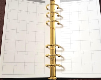 May include: An open brown leather planner featuring a gold-toned six-ring metal binder mechanism. The white paper inserts display a monthly calendar grid with columns for days of the week and a header section for month and date tracking.