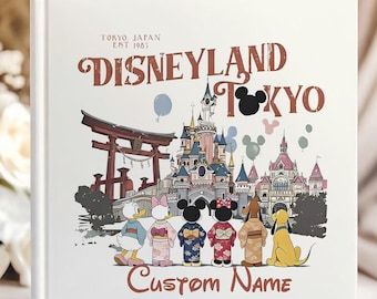 May include: A white photo album featuring a colorful illustration of Disneyland Tokyo. The cover includes the text "Disneyland Tokyo" and "Custom Name". The illustration depicts cartoon characters in traditional Japanese attire in front of a castle and a Japanese gate.