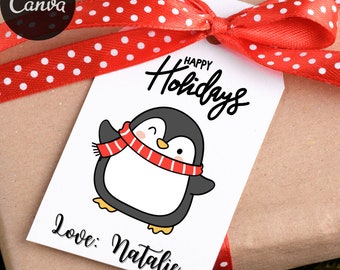 May include: A white gift tag with a cartoon penguin wearing a red and white scarf. The tag reads "Happy Holidays" and "Love: Natalie" in black script. A red ribbon with white polka dots is tied around the gift.