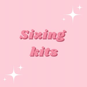 May include: A light pink graphic design featuring the text "Sixing kits" in a bold, dark pink, rounded font with a drop shadow effect. The design is accented by two white, four-pointed star shapes positioned in the top right and bottom left corners.