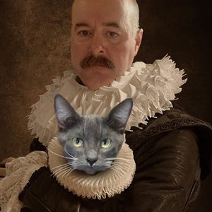 Puede incluir: Un hombre con una chaqueta marr&oacute;n y un cuello blanco con volantes sostiene un gato gris con un cuello blanco con volantes. El hombre tiene bigote y una expresi&oacute;n seria. El fondo es marr&oacute;n oscuro.