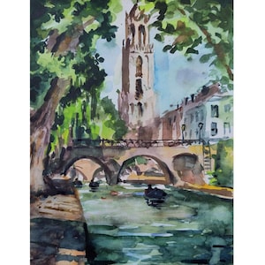 May include: Watercolor painting of a European cityscape featuring a bridge over a canal with boats. A tall church tower rises in the background, framed by lush green trees. The artwork uses shades of green, blue, and brown.