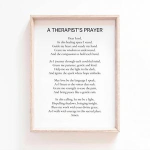 May include: A framed print with the text "A Therapist's Prayer" in black font. The poem is centered on a white background, enclosed in a light-colored wooden frame. The poem is a prayer for guidance and compassion.