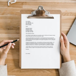 May include: A resignation letter on a clipboard with a black pencil on top of it. The letter is written in a formal tone and includes the date, recipient's name, and the sender's name.