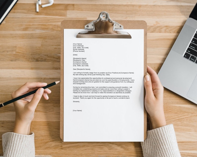 May include: A resignation letter on a clipboard with a black pencil on top of it. The letter is written in a formal tone and includes the date, recipient's name, and the sender's name.