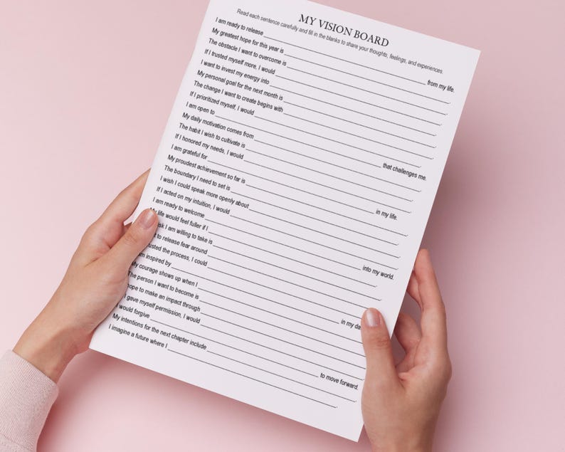 K&ouml;nnte beinhalten: Eine Person h&auml;lt ein wei&szlig;es Papier mit dem Titel "MY VISION BOARD". Das Papier ist liniert und enth&auml;lt Aufforderungen zum Ausf&uuml;llen. Der Hintergrund ist einfarbig hellrosa.