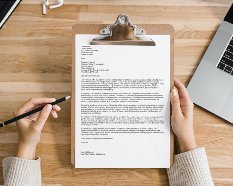 May include: A white letter of recommendation on a clipboard with a black clip. The letter is written in a formal tone and includes the words "Dear [Recipient's Name]" and "Sincerely".