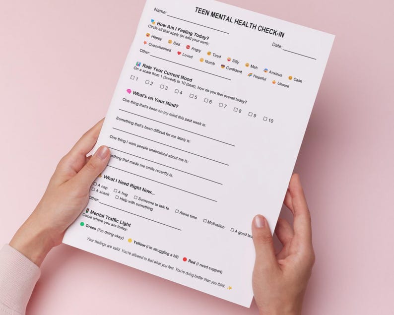Puede incluir: Una persona sostiene un papel blanco titulado "TEEN MENTAL HEALTH CHECK-IN". El formulario incluye secciones para calificar el estado de &aacute;nimo, identificar pensamientos y necesidades. El fondo es rosa.